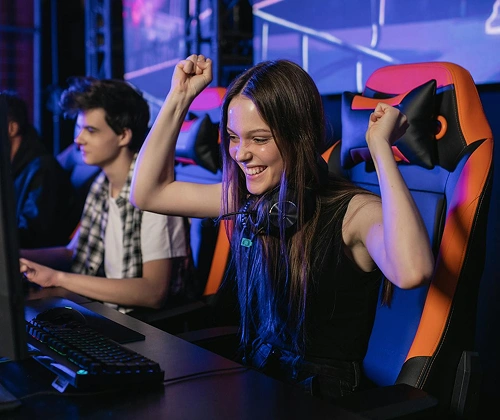 Een esports-team viert zijn overwinning bij een gamingstation met kleurrijke verlichting en een professionele gamingopstelling.